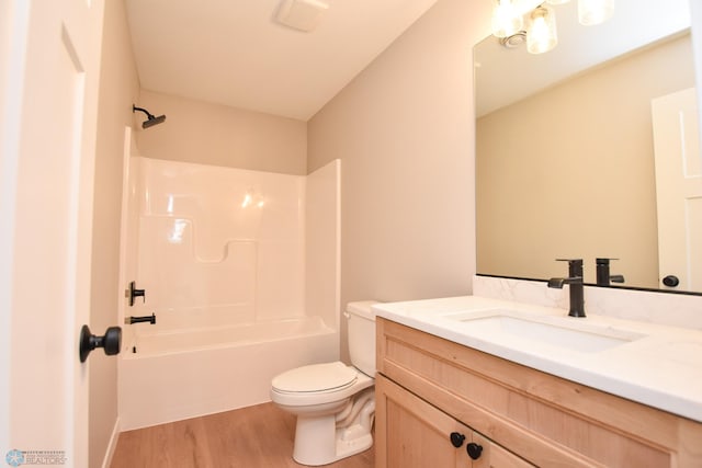 full bathroom featuring toilet, wood finished floors, tub / shower combination, and vanity
