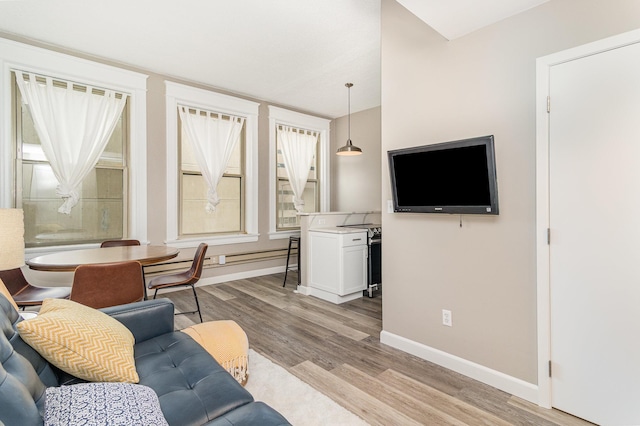 living area featuring light wood-style flooring and baseboards