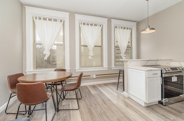 dining room featuring baseboards and light wood-type flooring