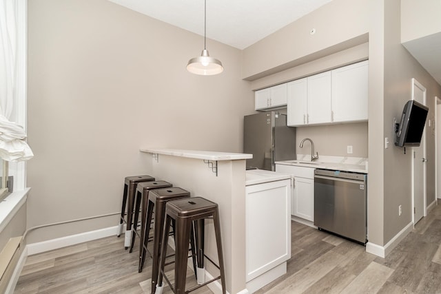 kitchen featuring light wood finished floors, a kitchen breakfast bar, and stainless steel appliances