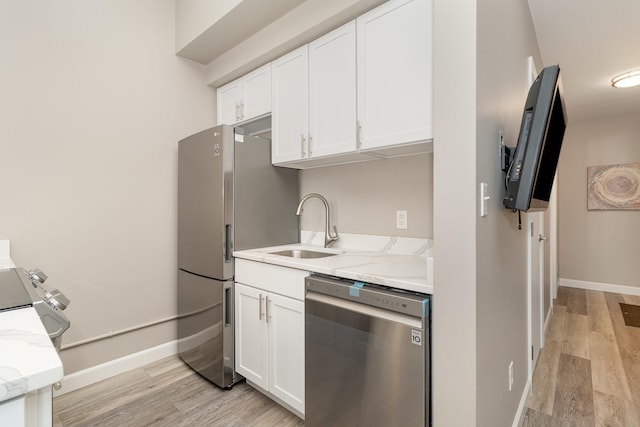 kitchen with light wood finished floors, white cabinets, and stainless steel appliances