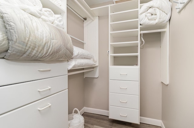 walk in closet with wood finished floors