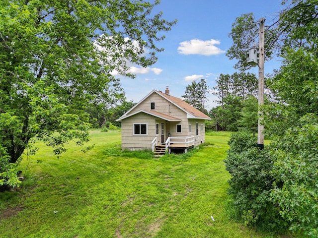 4235 277th Ave NW, Isanti, MN 55040 - back of house featuring a chimney and a yard