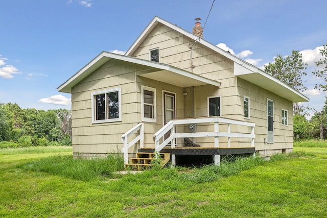 4235 277th Ave NW, Isanti, MN 55040 - back of property featuring a chimney, a wooden deck, and a yard