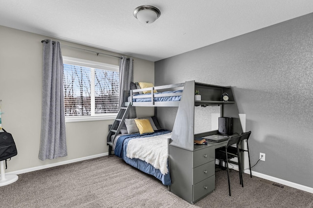 bedroom featuring visible vents, baseboards, carpet flooring, and a textured wall