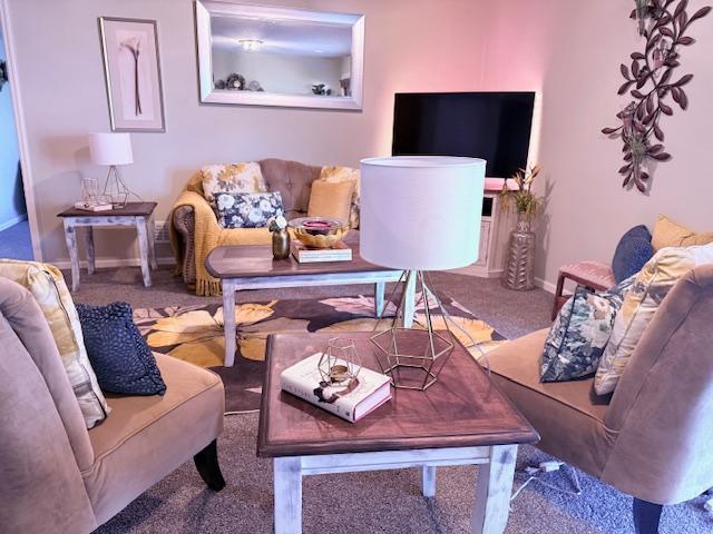 carpeted living area with baseboards