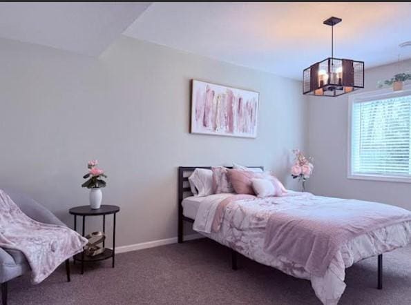 carpeted bedroom with baseboards and a notable chandelier