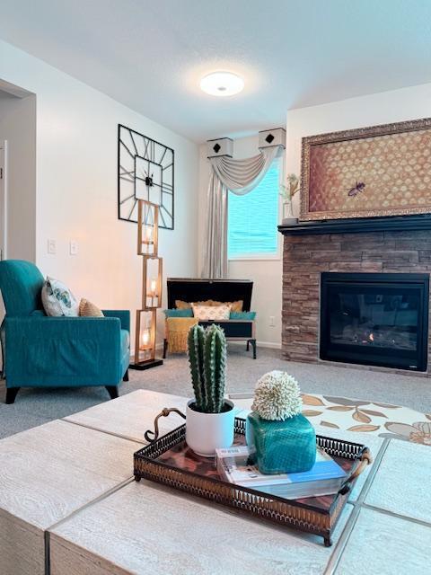 living room with a glass covered fireplace, carpet, and baseboards