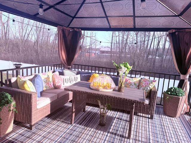 wooden deck with an outdoor living space and a gazebo