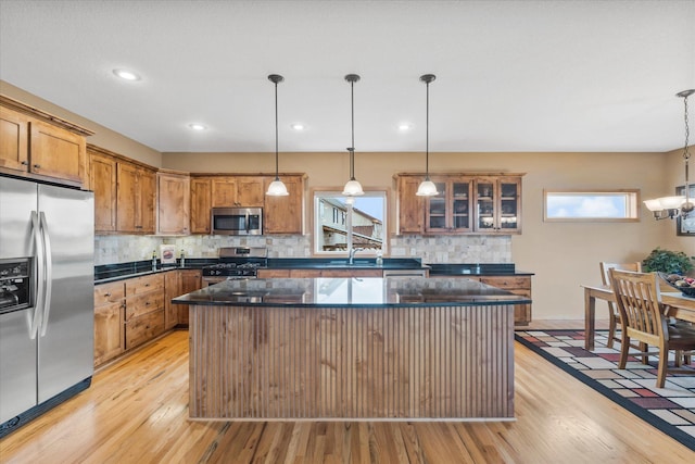 kitchen with brown cabinetry, appliances with stainless steel finishes, and light wood-style floors