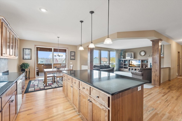 kitchen with a center island, dark countertops, a healthy amount of sunlight, and light wood-type flooring