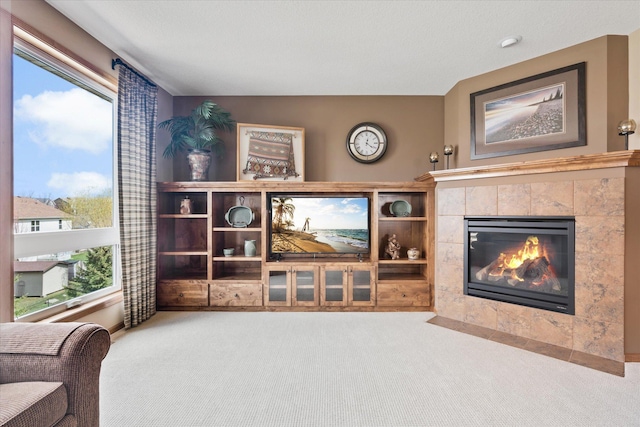sitting room featuring a tiled fireplace and carpet