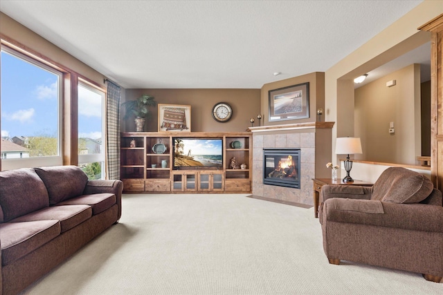 carpeted living area with a tile fireplace
