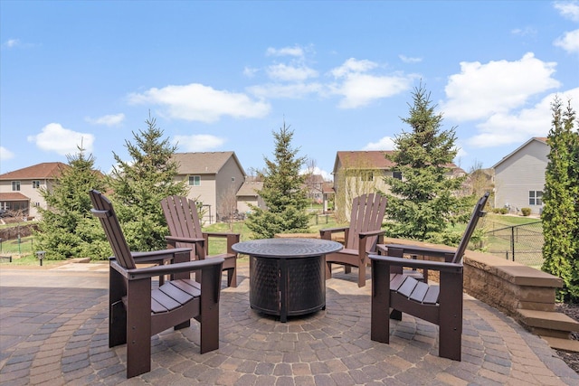 view of patio featuring fence, a fire pit, and a residential view