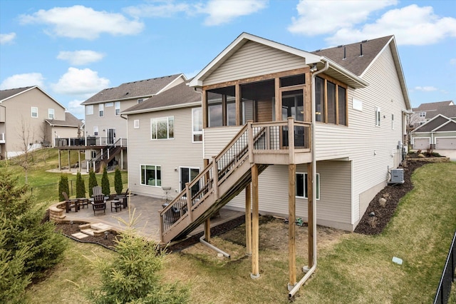 back of house with a fire pit, stairway, a patio, and a sunroom