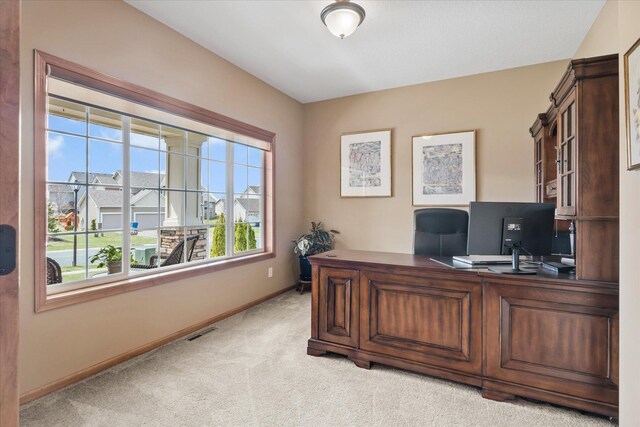 office area with visible vents, light carpet, and baseboards