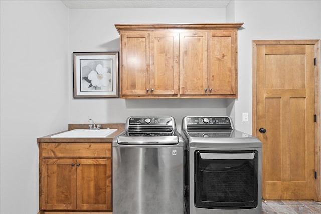 laundry area featuring separate washer and dryer, cabinet space, and a sink