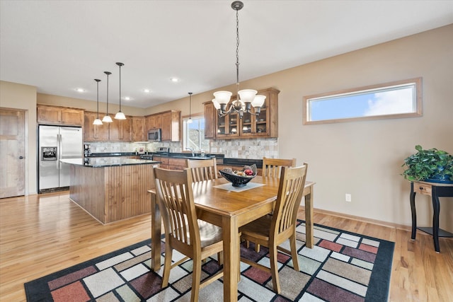 dining space featuring a chandelier, light wood-style flooring, baseboards, and recessed lighting