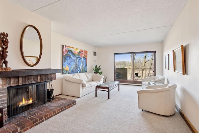 carpeted living area with baseboards, a fireplace, and a textured ceiling