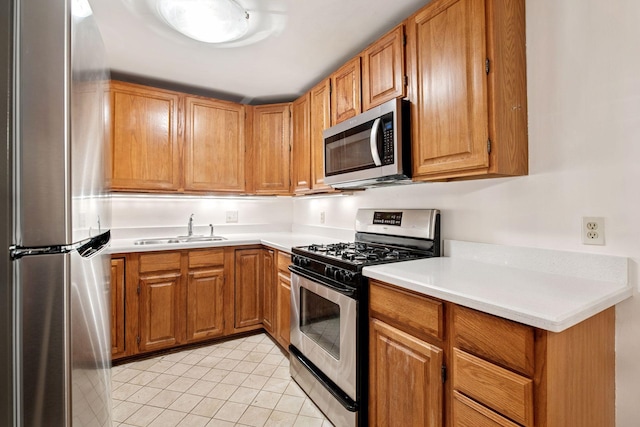 kitchen featuring a sink, brown cabinetry, light tile patterned floors, stainless steel appliances, and light countertops