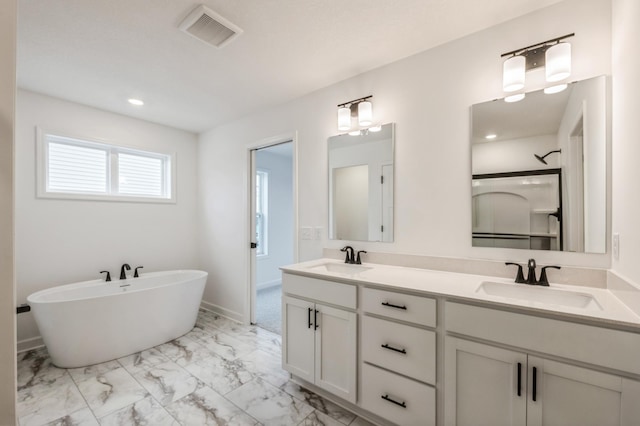 full bathroom featuring a freestanding tub, visible vents, a sink, and marble finish floor