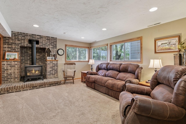carpeted living area featuring recessed lighting, a wood stove, and a textured ceiling