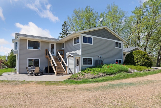 rear view of house with stairs, a patio, and central AC