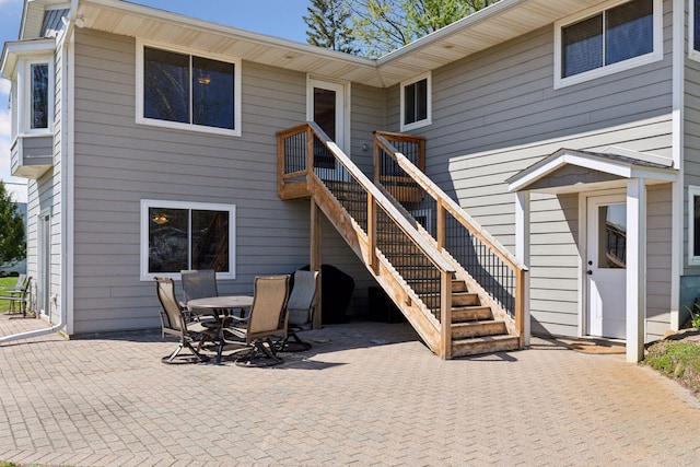 rear view of house featuring a patio, outdoor dining area, and stairs