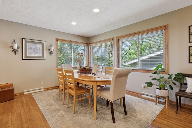 dining space with baseboard heating, baseboards, a textured ceiling, light wood-style flooring, and recessed lighting