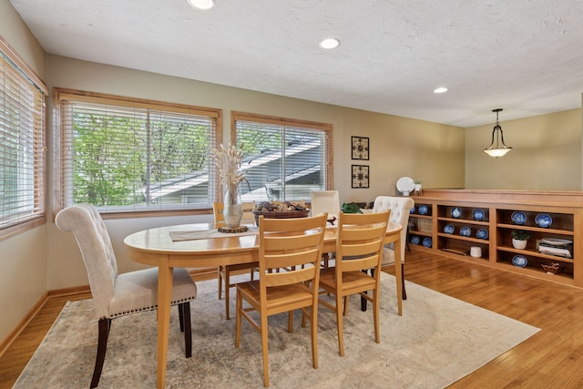 dining space featuring wood finished floors, recessed lighting, and a textured ceiling
