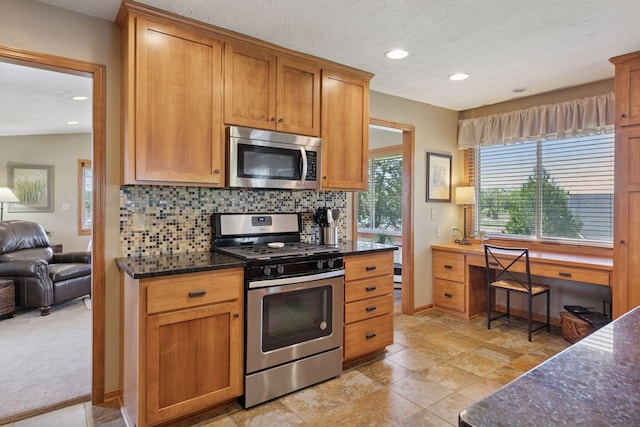 kitchen with appliances with stainless steel finishes, backsplash, healthy amount of natural light, dark stone counters, and recessed lighting