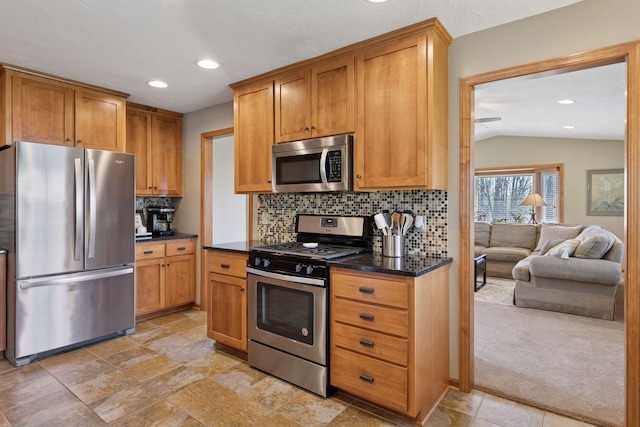 kitchen featuring stainless steel appliances, tasteful backsplash, vaulted ceiling, recessed lighting, and brown cabinets