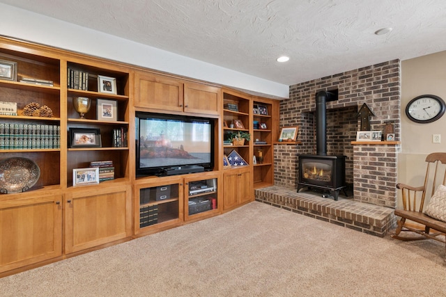 living room featuring a wood stove, carpet, and a textured ceiling