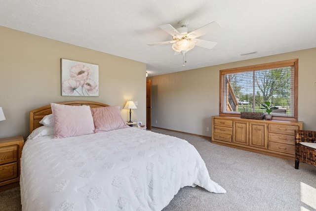 bedroom featuring light colored carpet, ceiling fan, and baseboards