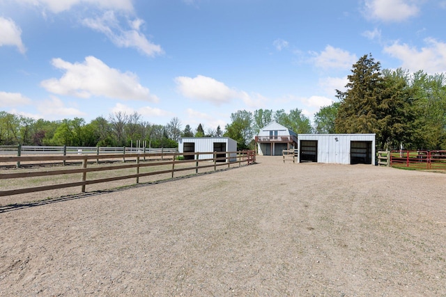 view of street with a pole building, an exterior structure, an enclosed horse arena, and a view of countryside