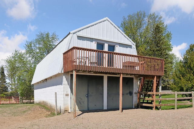 rear view of property with a deck, fence, and board and batten siding