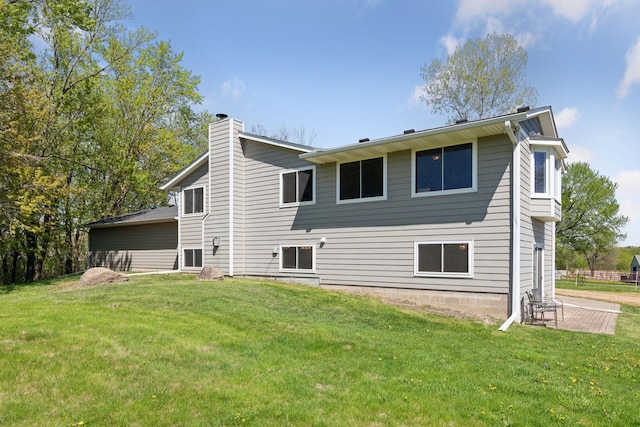 back of property featuring a chimney and a lawn