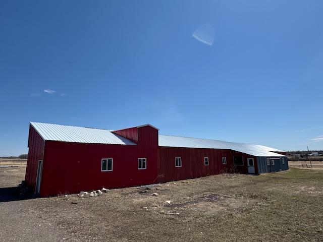 view of home's exterior with a pole building and an outbuilding