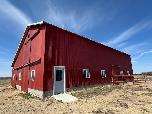 view of pole building featuring fence and a barn