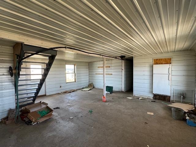 unfurnished living room featuring unfinished concrete flooring and a garage