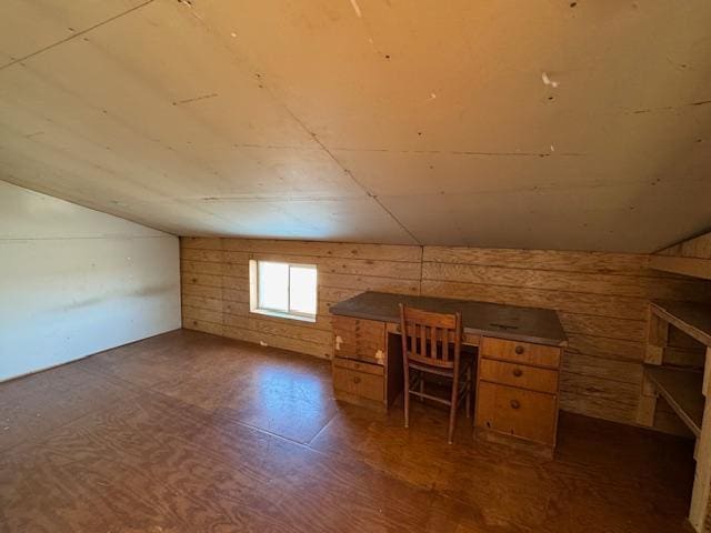 additional living space featuring wood walls and vaulted ceiling