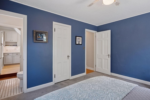 bedroom featuring baseboards, carpet, ensuite bath, and ornamental molding