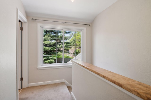corridor with baseboards and carpet