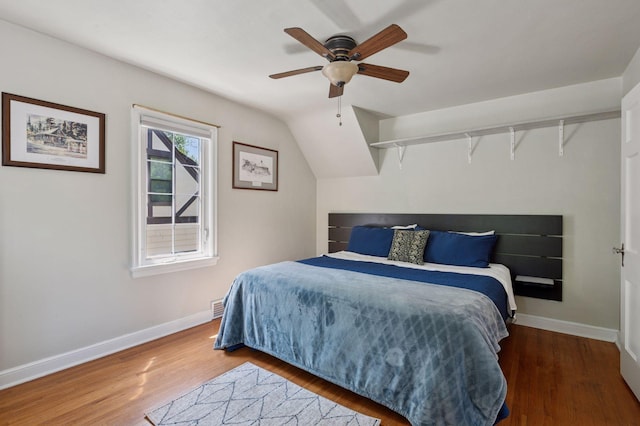 bedroom featuring wood finished floors, baseboards, and a ceiling fan