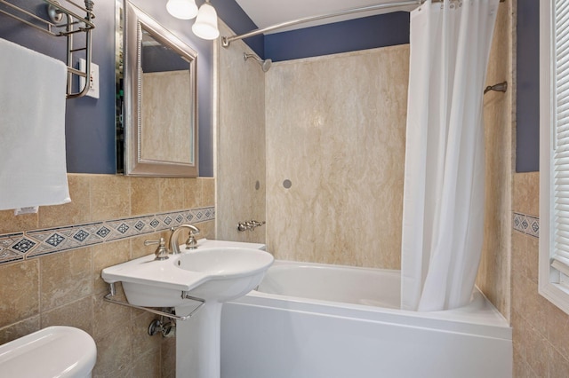 bathroom featuring tile walls, shower / tub combo, and toilet