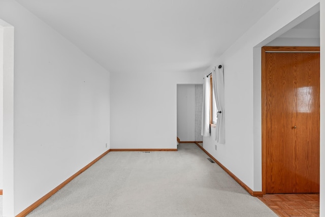 empty room featuring baseboards and carpet