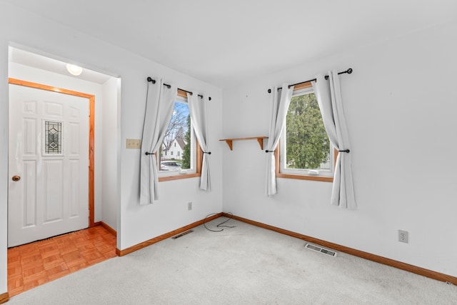 empty room with baseboards and visible vents