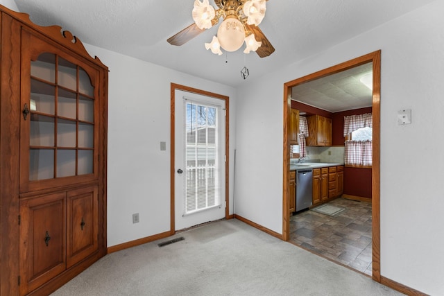 entryway with a sink, ceiling fan, visible vents, baseboards, and carpet floors