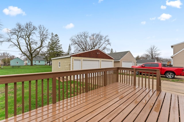 wooden deck featuring an outdoor structure, a detached garage, a lawn, and a residential view