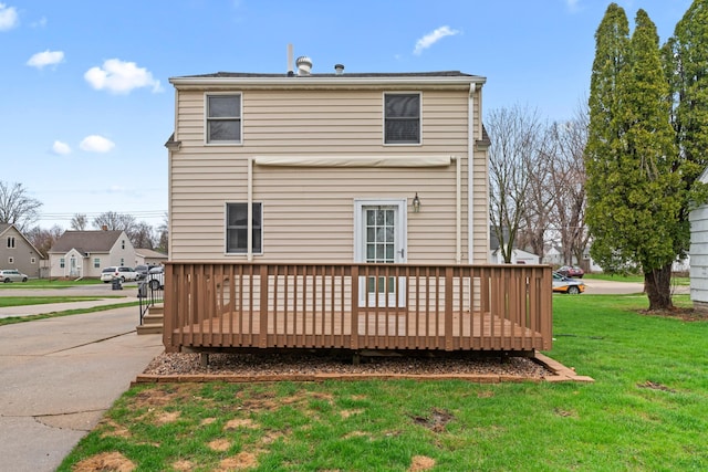 rear view of house with a yard and a wooden deck